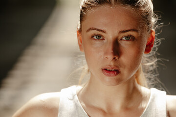 Close up photo of athletic blonde woman sweating taking a break from workout.