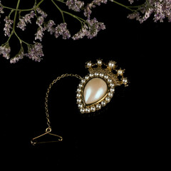 vintage gold brooch in the shape of a crown with pearls. antique crown brooch in flowers