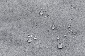 Waterproof droplets on fabric. Grey Canvas Polyester texture synthetical for background. Black polyester textile backdrop for interior art design or add text message.