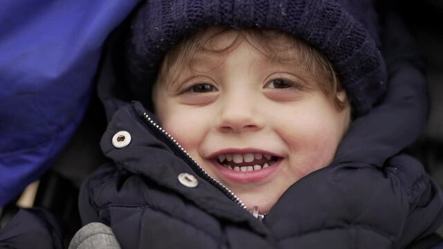 Cute little baby boy face smiling wearing winter clothing, close-up face