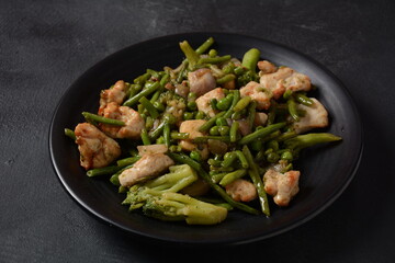 Baked vegetables, broccoli, beans, peas and fried pieces of chicken breast. Healthy food concept.
