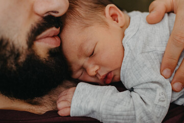 home photos of a newborn baby in the arms of father. Selective focus, noise effect