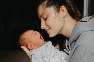 home photos of a newborn baby in the arms of mother. Selective focus, noise effect