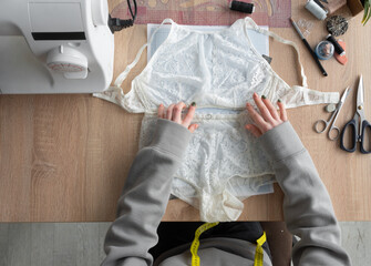 Flat lay, hands of a lingerie designer. Underwear making.