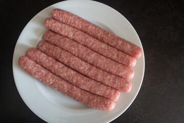 Raw sausages on a plate