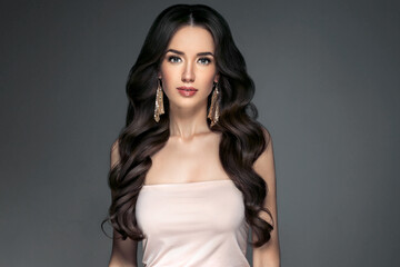 Fototapeta premium Beautiful woman with long hair, shine and curly, beauty girl female over darl gray background
