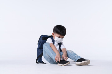 Asian boy about 4 years old wearing chemical face mask and student backpack