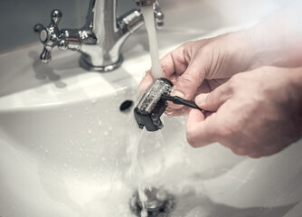 Washing the shaving head from the electric shaver under running water in the tap. Daily care of the...