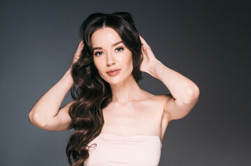 Fototapeta premium Beautiful woman with long hair, shine and curly, beauty girl female over darl gray background