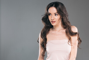 Fototapeta premium Beautiful woman with long hair, shine and curly, beauty girl female over darl gray background