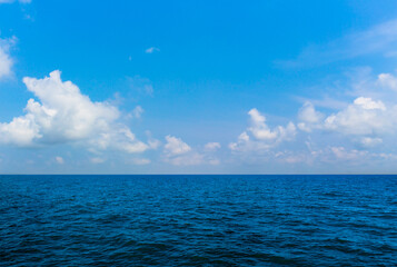 Water surface with Deep Blue sea and clear sky clouds. Landscape with Ocean small waves water reflection. Illustration for tourism, website or advertisement. Andaman sea, Thailand.