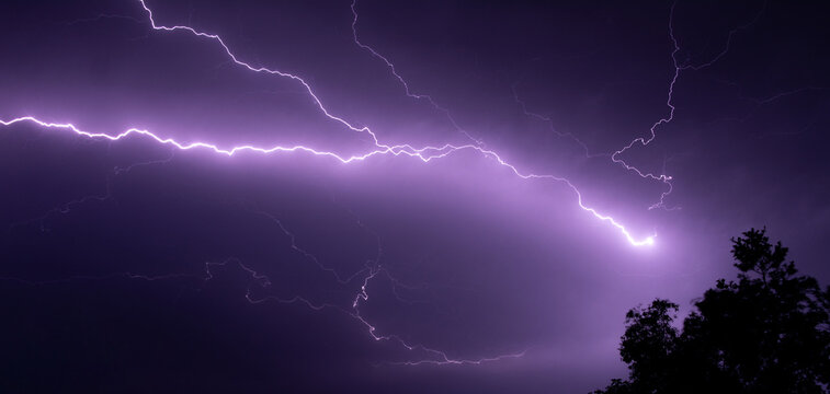 Lightning at night Which causes a white beam of light Contrast purple sky