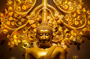 Golden Buddha statue with golden bodhi tree