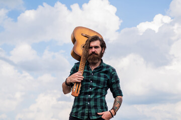 Music makes you smarter. casual styled guitarist. modern looking bearded hipster with acoustic...