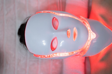Woman with led light therapy facial and neck beauty mask photon therapy. Home skincare and me time...