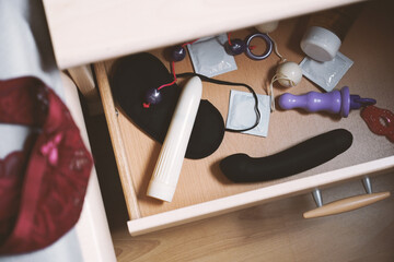 bedside table or nightstand drawer full of sex toys