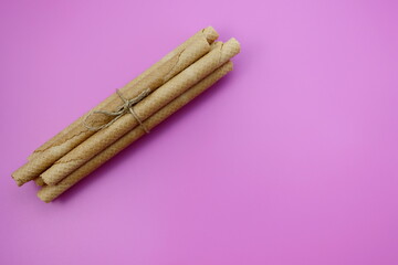 Long wafer rolls on a pink background.
Waffle - a kind of thin dry biscuits 