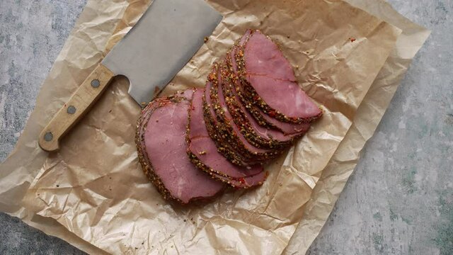 Delicious peppered roast beef pastrami slices on paper with grains of coloured pepper