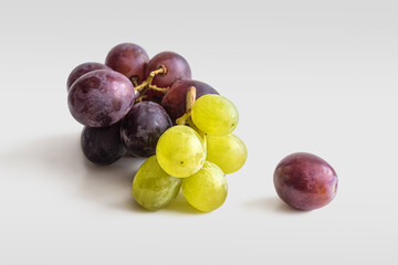 Red and green grapes on a light background