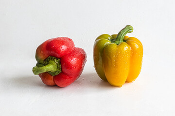 Red and yellow bell peppers, with water drops on the sides