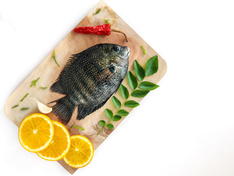 pearl spot fish /Karimeen decorated with herbs and fruits. isolated on white Background.Selective focus.
