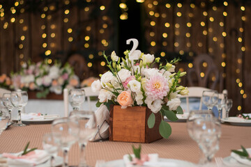 Fototapeta na wymiar table centerpiece with white and peach rustic floral arrangement in wood box. Rustic wedding table.