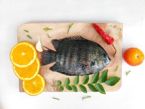 pearl spot fish /Karimeen decorated with herbs and fruits. isolated on white Background.Selective focus.