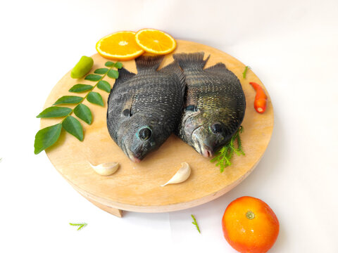 pearl spot fish /Karimeen decorated with herbs and fruits. isolated on white Background.Selective focus.