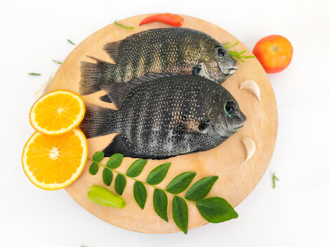 pearl spot fish /Karimeen decorated with herbs and fruits. isolated on white Background.Selective focus.