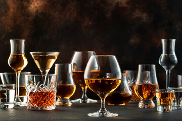 Hard strong alcoholic drinks, spirits and distillates in glasses in assortment: vodka, cognac,...