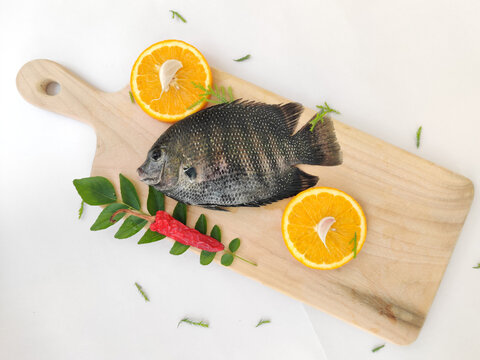 pearl spot fish /Karimeen decorated with herbs and fruits. isolated on white Background.Selective focus.