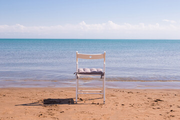 white chair stands on the seashore