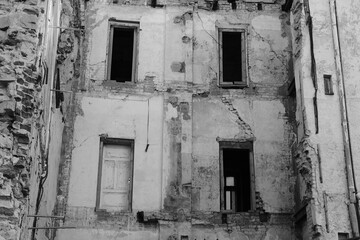 Black and white photo of a street in the old town of Riga with crumbling houses