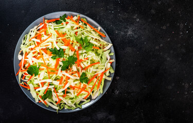 Coleslow cabbage salad with carrot on grey kitchen table. Top view, copy space