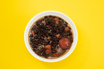 black beans with meat and sausages in white bowl