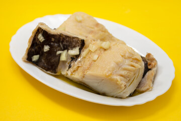 boiled cod fish with olive oil on white dish