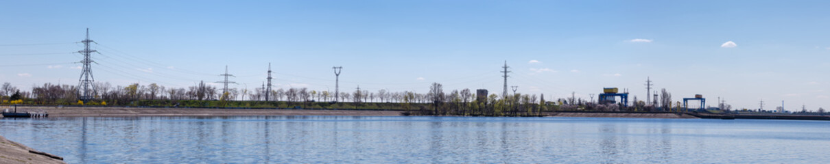 Dam on reservoir, hydroelectric power station and overhead power lines