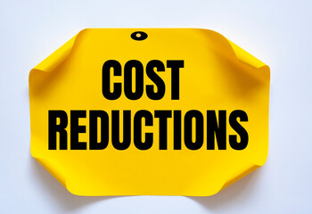 Cost Reductions words on copybook page. Production or reselling Business concept for reduction expenses for goods and services.