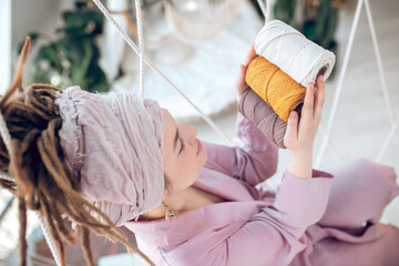 Woman in a headwear holding yarn in her hands