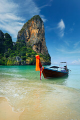 Obraz premium long tail boat, in white sand beach in andaman sea with view of limestone island 