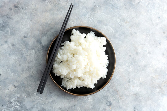 Sushy rice with chopsticks isolated top view