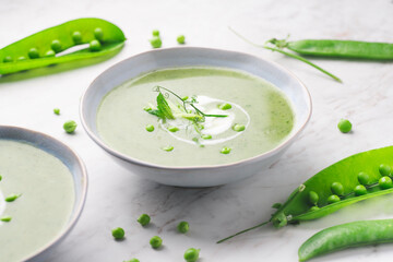 Delicate spring green cream soup with green peas and mint, white background. Spring or summer vibrant healthy vegetarian menu,for farm-to-table, green recipes, close up