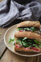 Sandwich with whole grain bread, salami and arugula