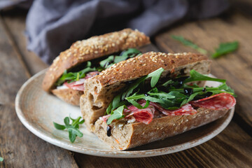 Sandwich with whole grain bread, salami and arugula