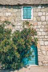 Fototapeta na wymiar Traditional stone house with blue door and window in Croatia
