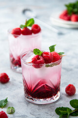 Raspberry cold drink cocktail with mint leaf and ice cubes. Summer fresh beverage in glass.