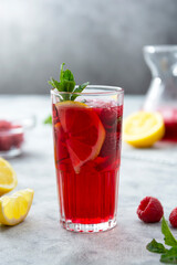 Fototapeta na wymiar Summer raspberries cold drink with lemon, mint and berries. Homemade cocktail.