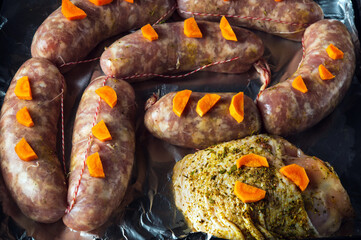 Raw meat sausage with carrots and ham on a Sheet pan close-up is prepared for baking in the oven....