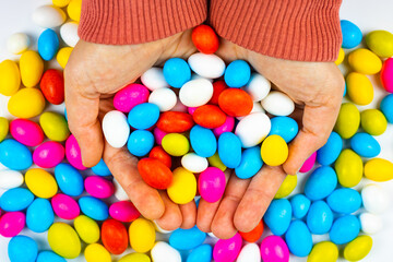 Fototapeta na wymiar Colorful candies in the woman's hands. Eid Mubarak