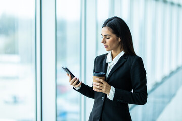 Obraz premium Young business woman use phone for text or surfing in internet in modern office.